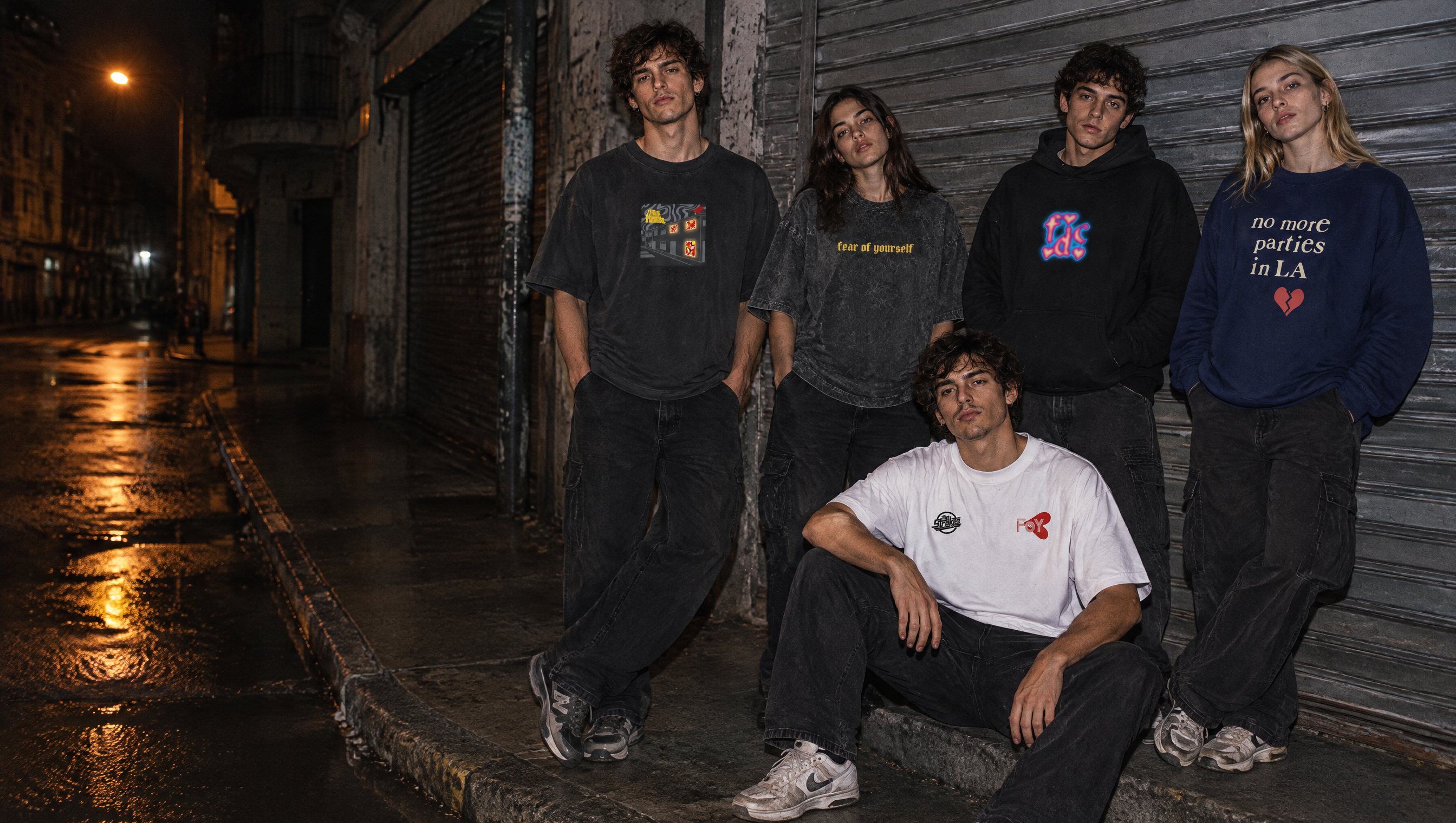Cinco modelos con prendas del drop 01 en una vereda de Buenos Aires de noche